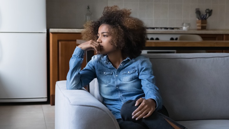 Unhappy Black woman on sofa