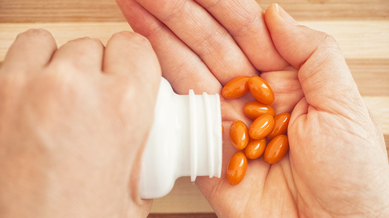 person pouring CoQ10 pills into hand