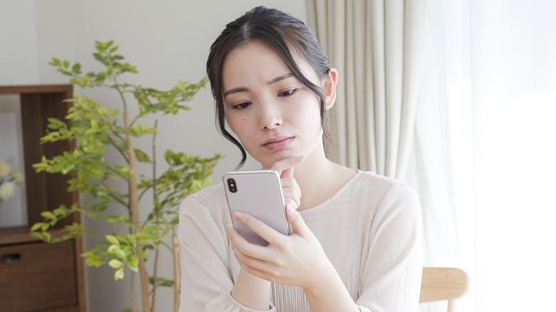 concerned woman looking at phone