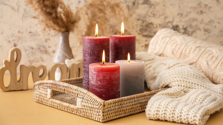 Candles burning next to rolled up sweater