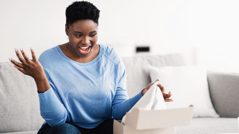 Woman opening a box looking unhappy