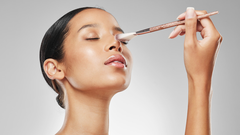 woman applying highlighter to nose