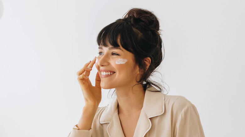 woman applying makeup to cheeks