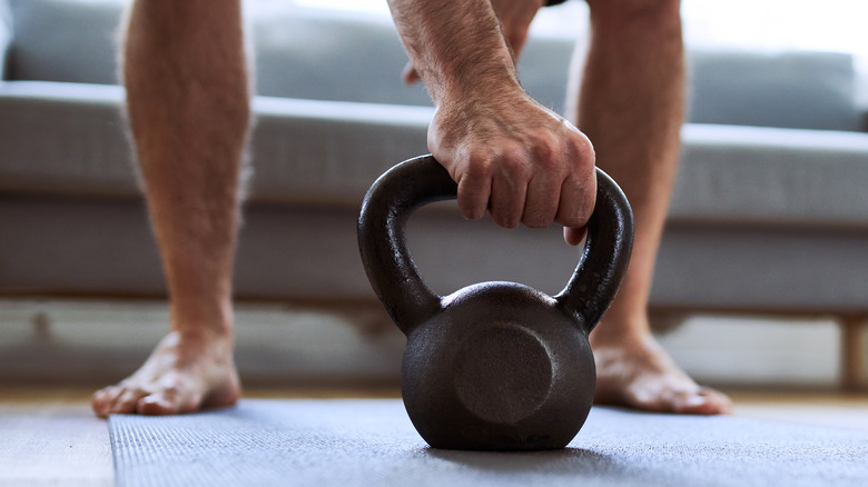man lifting weight barefoot