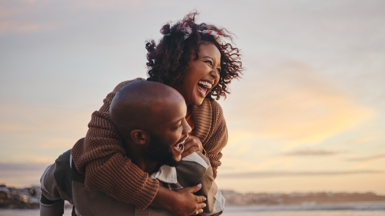 woman riding on man's back