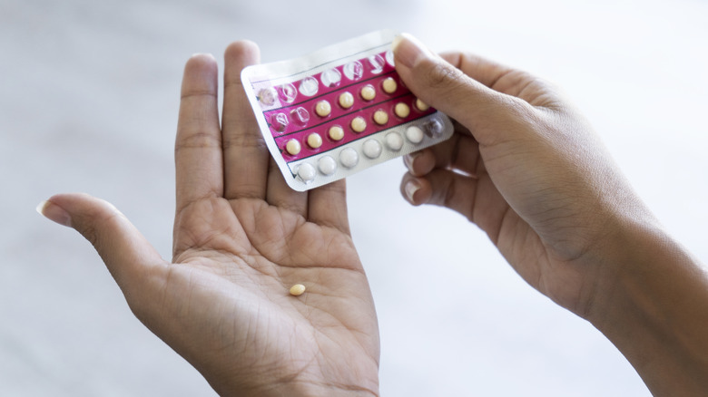 Hand holding birth control pills 