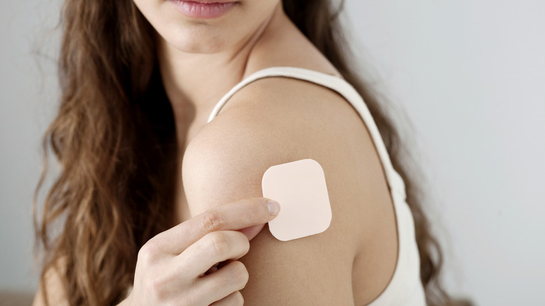 Woman applying birth control patch 