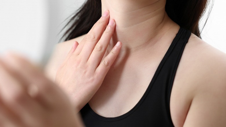 Woman looking at her neck