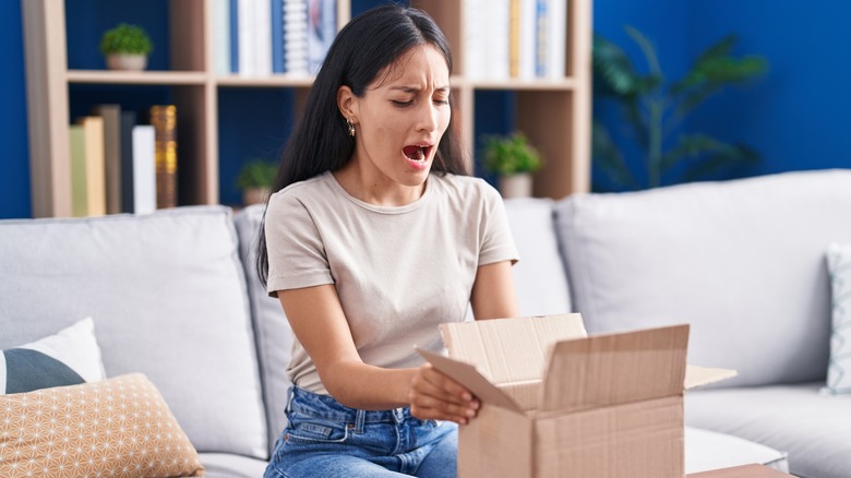 annoyed woman opening gift