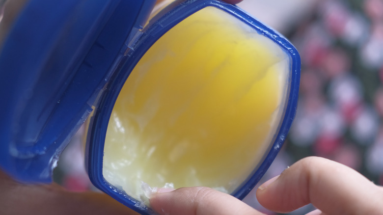 Vaseline jar with finger taking product out