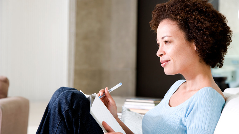 Woman sitting down journaling 
