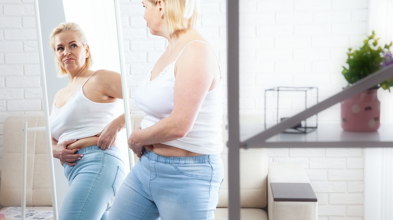 Woman criticizes body in mirror