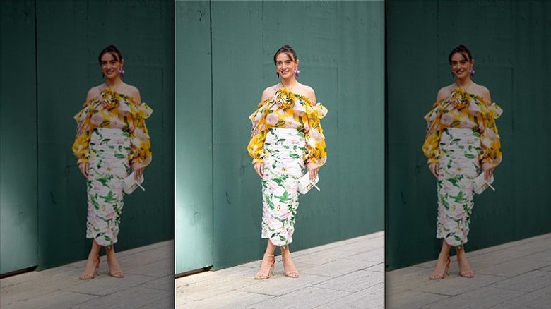 woman wearing ruffled off the shoulder top and midi skirt