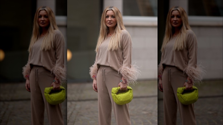 Woman in beige outfit with neon handbag