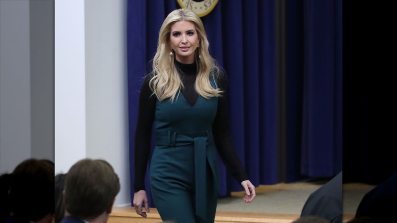 Ivanka Trump wearing a green jumpsuit over a turtleneck.
