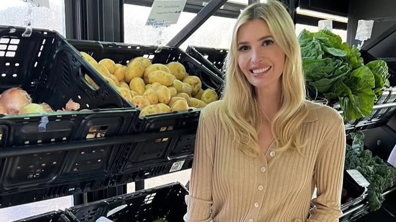Ivanka Trump smiling next to racks of produce