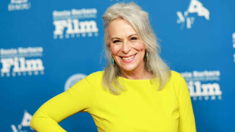 Jane Kaczmarek wearing a bright yellow dress and green drop earrings in 2024