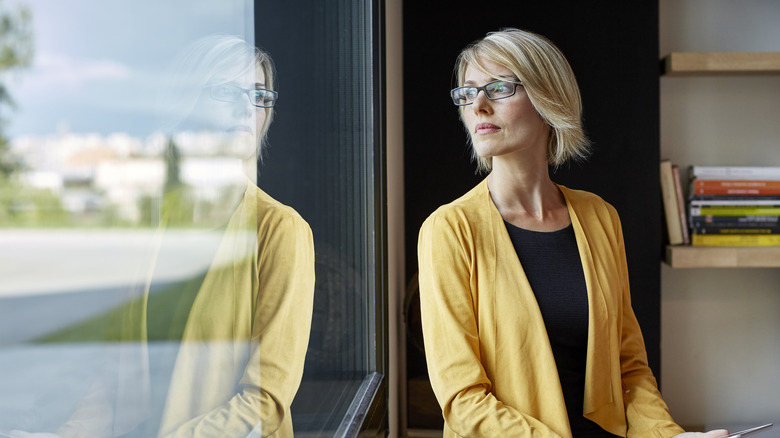 Woman staring outside window thinking