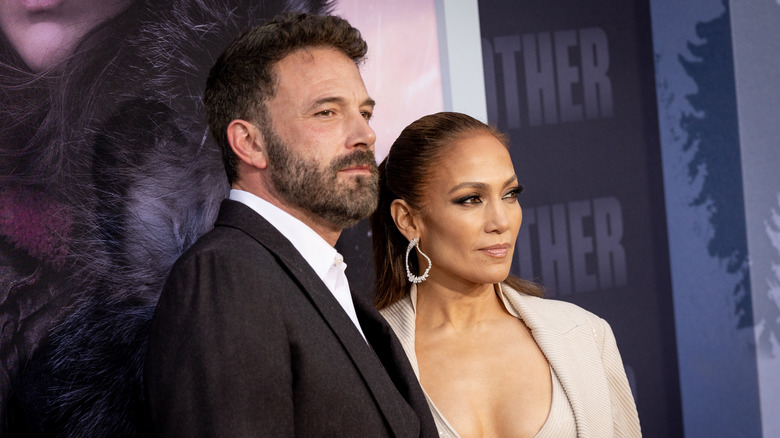 Jennifer Lopez looking at herself in the mirror wearing a dress with a long train for her wedding to Ben Affleck in 2022.