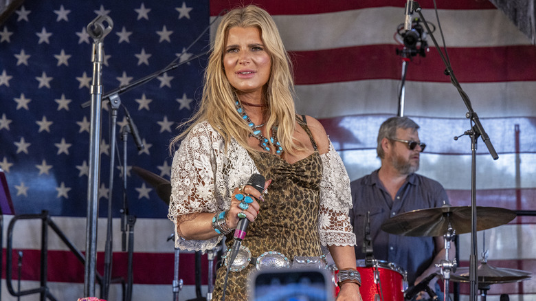 Jessica Simpson with dirty-blond hair while performing in a leopard outfit