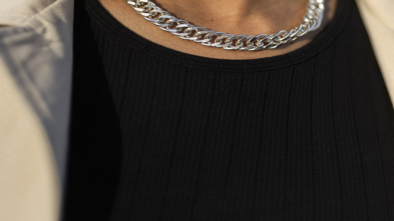 Closeup of a woman's neck wearing choker necklaces.