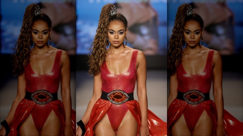 model wearing red swimsuit with gem