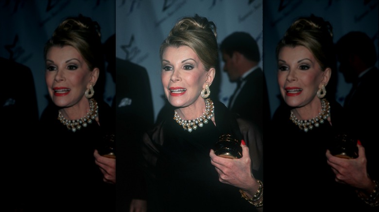 Joan Rivers photographed at a red carpet event with an updo and pearls.