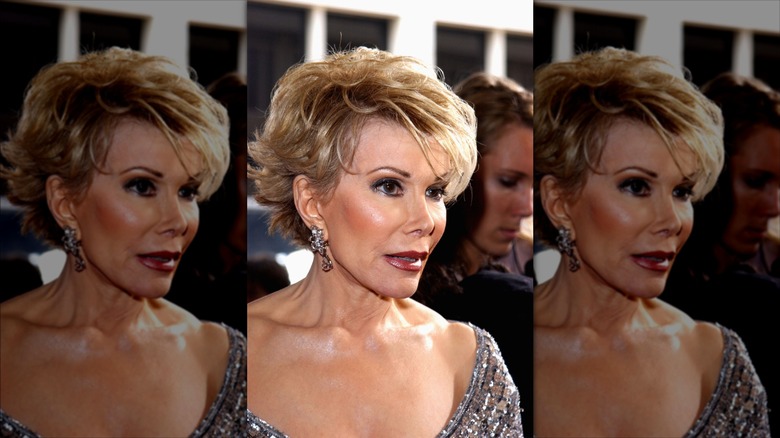 Joan Rivers photographed in a silver dress with short hair and dangly earrings.