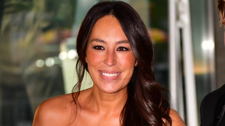 Joanna Gaines smiling with a sleek side ponytail.