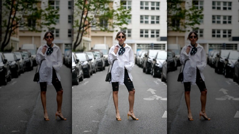 Woman wearing button-down, distressed jorts