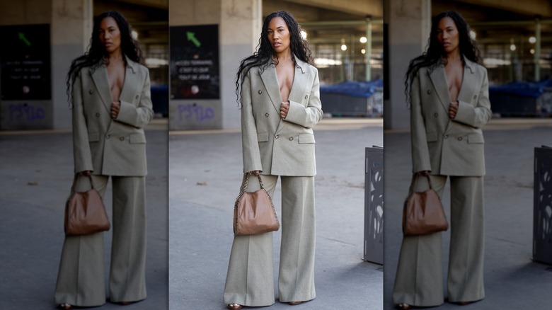 A woman wearing an oversized gray suit