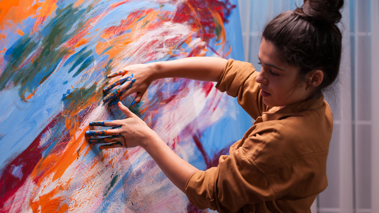 young woman painting in art gallery