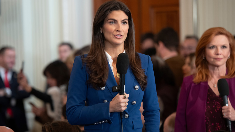 Kaitlan Collins speaks into a microphone during a newscast