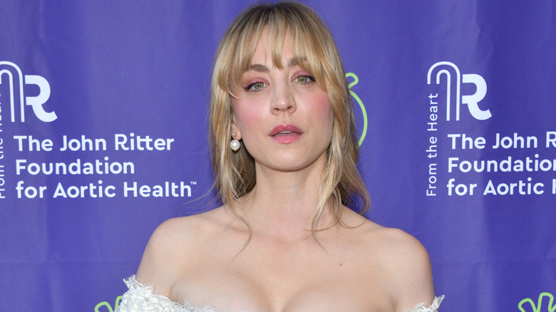 Kaley Cuoco on the red carpet posing in a white outfit
