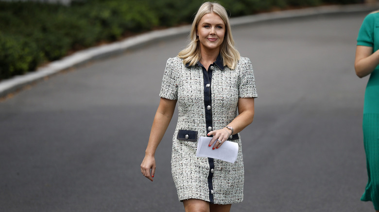 Karoline Leavitt walking outside in a short tweed dress