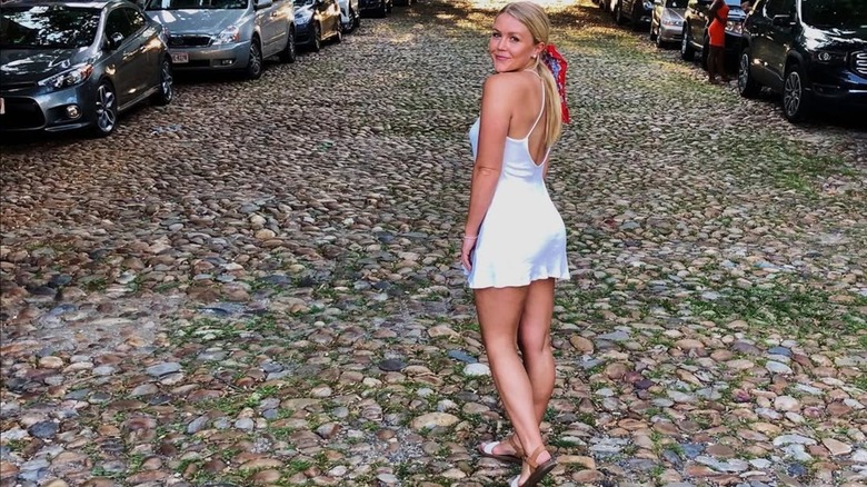 Karoline Leavitt posing in a white minidress