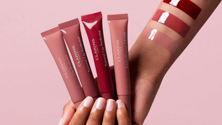 hand holding Clarins lip glosses