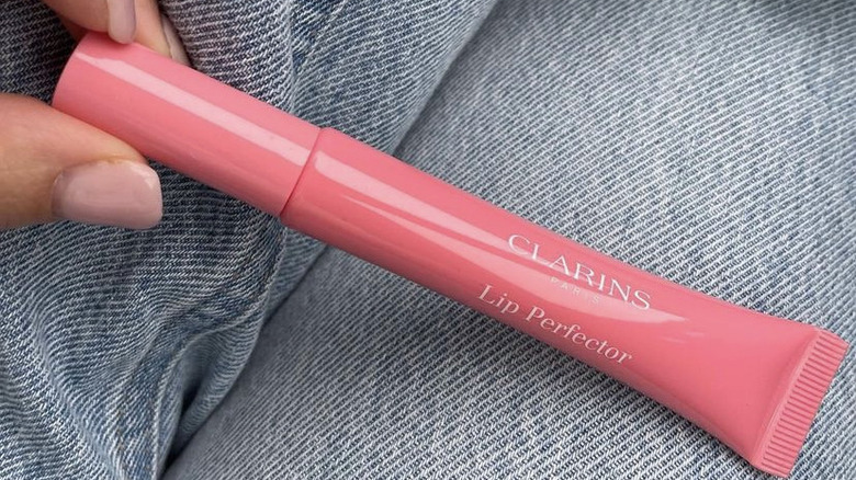 person holding Clarins lip gloss