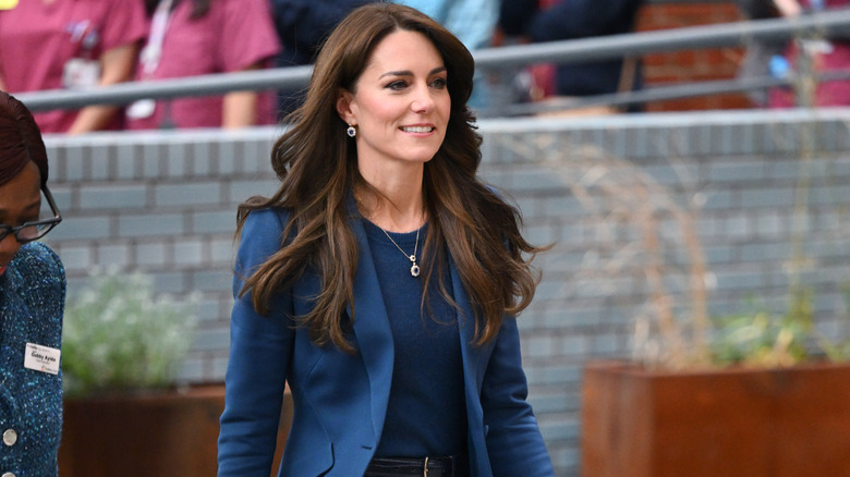 Princess Catherine smiles while walking in a green pantsuit