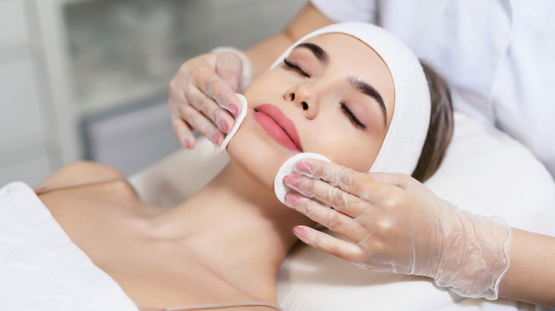 Woman receiving facial treatment