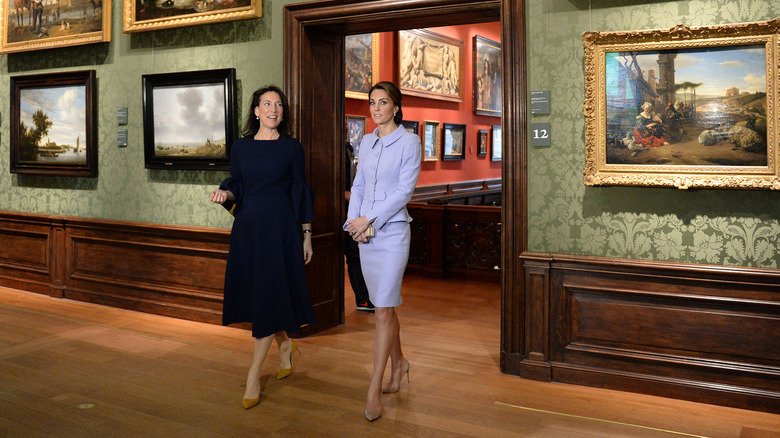 Kate Middleton standing in purple suit set