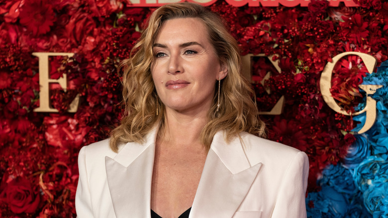 Kate Winslet posing against a media wall
