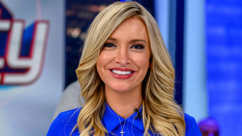 Kayleigh McEnany posing in a blue shirt with a cross necklace