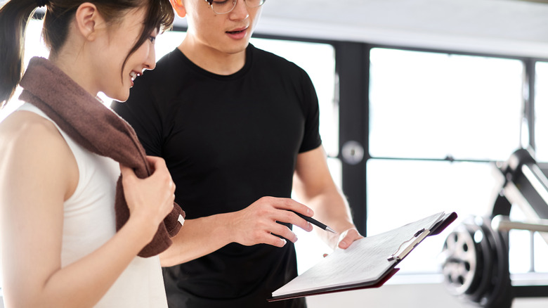 Trainer examining paper with client