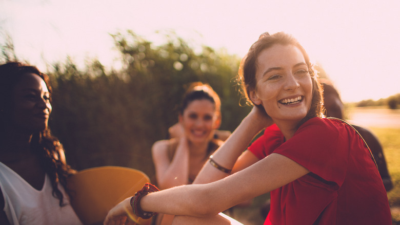 Women smiling, sitting on grass
