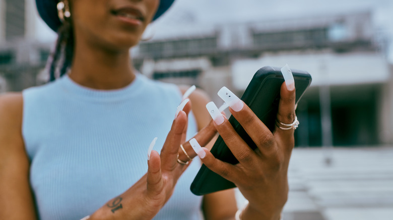 Woman with long nails phone