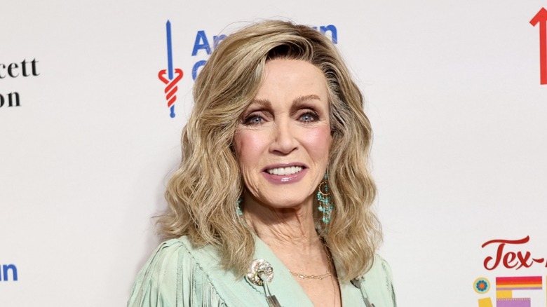 Photo of Donna Mills smiling in front of a media wall.