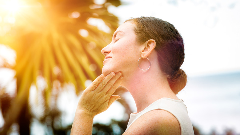 girl rubbing sunscreen on neck