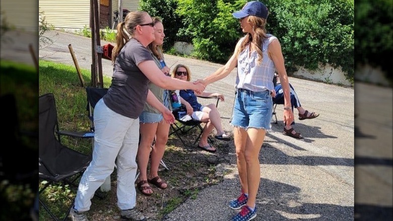Kristi Noem shakes hand with a woman on the Fourth of July