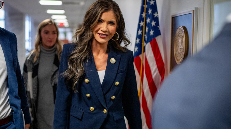 Kristi Noem in a blazer and earrings with a white top underneath